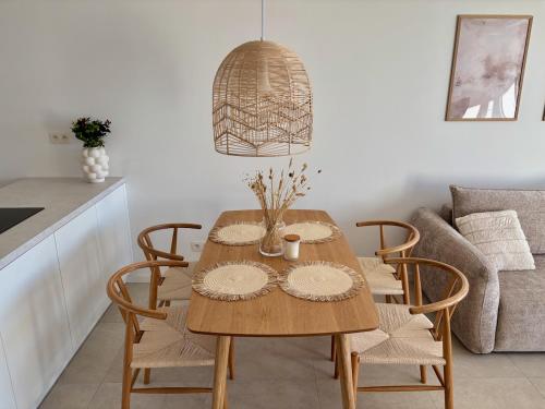 a dining room table with chairs and a couch at Bluewave boho apartment Slnava in Banka