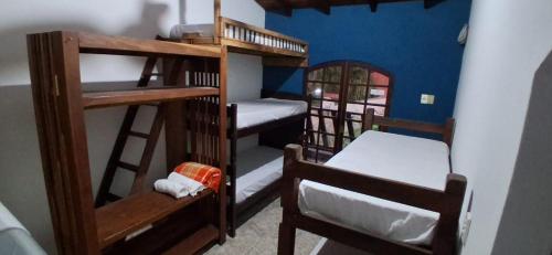a room with two bunk beds and a chair at Pousada e Hostel La Civetta - Maresias in São Sebastião