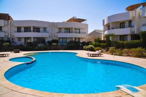 a large blue swimming pool in front of a building at MARIA HOSTEL FOREIGNERS ONLY-CRISS RESORT-NAAMA BAY-CITY CeNTER in Sharm El Sheikh