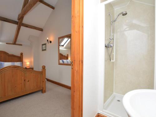 a bathroom with a shower and a sink and a bed at 2 bed in Bude CORYW in Morwenstow