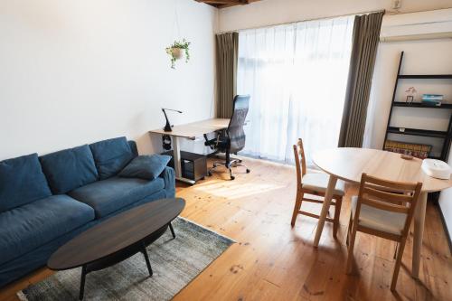 a living room with a blue couch and a table at 一棟貸し宿 Guest House Mado in Soja