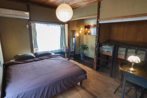a bedroom with a large bed and a window at 一棟貸し宿 Guest House Mado in Soja