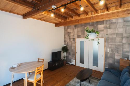 a living room with a blue couch and a table at 一棟貸し宿 Guest House Mado in Soja