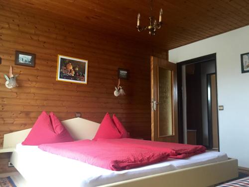 een bed met roze kussens in een houten kamer bij Haus Kernstock in Salzburg