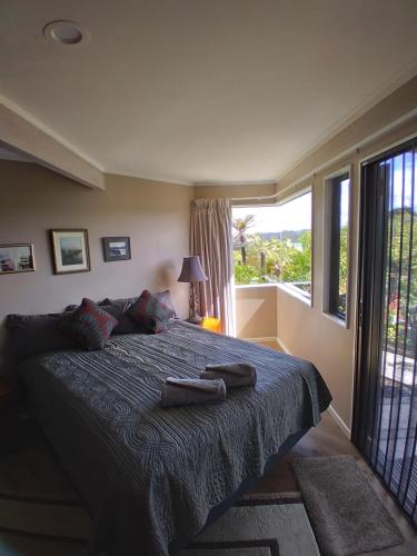 a bedroom with a bed with a blue blanket and a window at The Tawnys in Russell