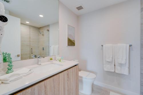 a white bathroom with a sink and a toilet at 3900-902CH DESIGN DISTRICT, CONDO 2 BEDROOMS & 2 BATHROOMS in Miami