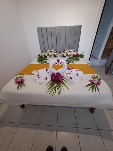 a bed with two swans dressed in flowers on it at Kaz'Agatha in Sainte-Anne