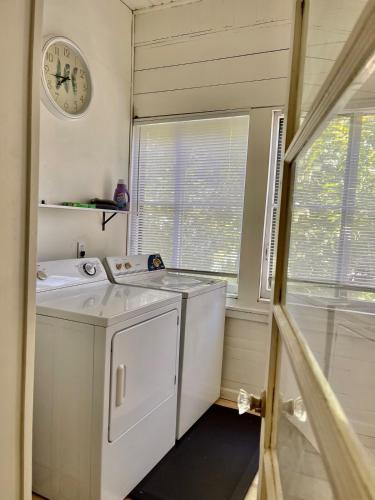 a laundry room with a washing machine and a clock at Downtown Updated Craftsman, Pet Friendly in Sonora