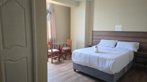 een slaapkamer met een bed, een tafel en stoelen bij MOON Edificio in San Vicente de Cañete