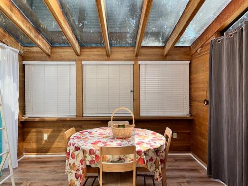 a dining room with a table and chairs and windows at Edgewood Road in North Vancouver