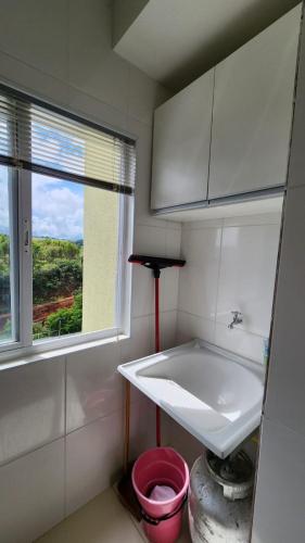 ein kleines Badezimmer mit Waschbecken und Fenster in der Unterkunft Apartamento Tennis Prime in Oliveira