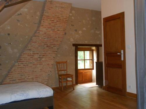 a bedroom with a staircase with a brick wall at Maison de Caractère Rénovée avec Jardin, Terrasse, et Proche du Château Guillaume - FR-1-591-131 in Lignac