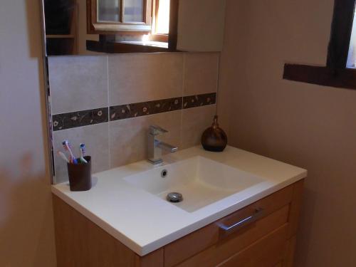 a bathroom with a white sink and a mirror at Maison de Caractère Rénovée avec Jardin, Terrasse, et Proche du Château Guillaume - FR-1-591-131 in Lignac