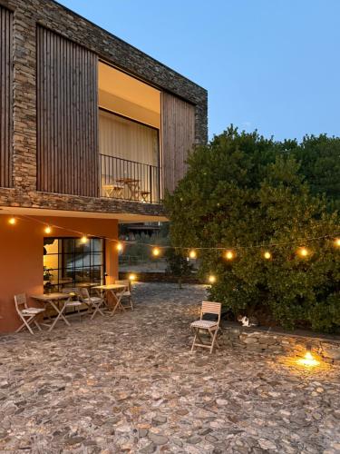a building with a table and chairs in front of it at Quinta das Levadas - Country House & Nature in Alvoco das Várzeas