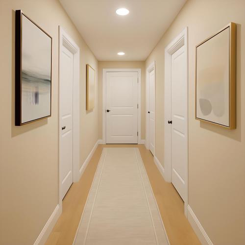 a hallway with white doors and paintings on the walls at Jackson Pearl in Jackson