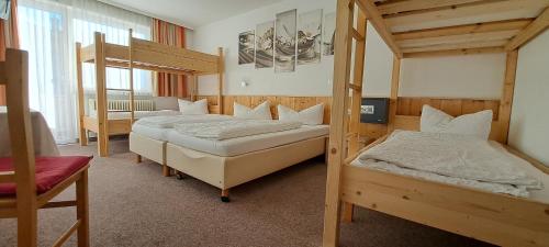 two beds in a room with two bunk beds at Gasthof Hotel Kirchenwirt in Zell am Ziller