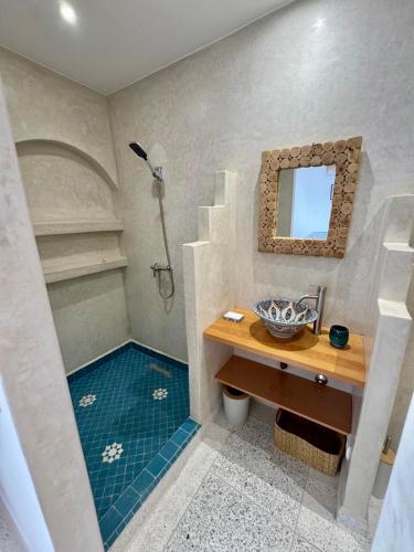 a bathroom with a shower with a sink and a mirror at Riad Lalla Naty in Agadir