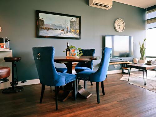 a dining room with a table and blue chairs at Horizon King-bed Lux Apt Free Parking in Sydney
