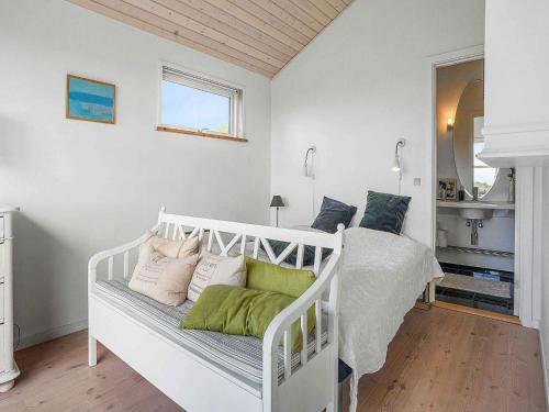 a white bed with pillows on it in a room at 5 star holiday home in Allingåbro in Rygård Strand
