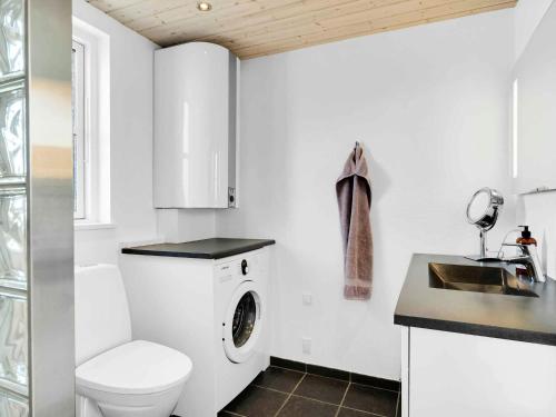 a white bathroom with a toilet and a sink at 5 star holiday home in Karrebæksminde in Karrebæksminde