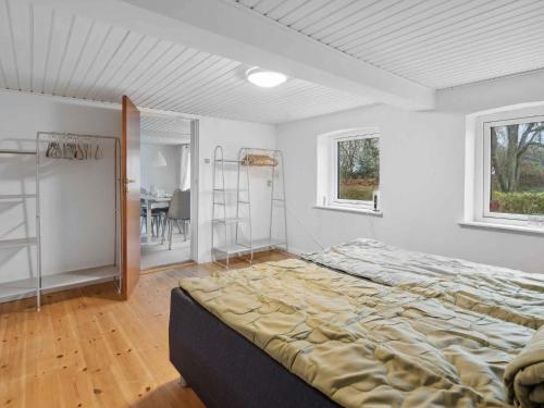 a bedroom with a large bed and a table at 5 star holiday home in Haderslev in Flovt