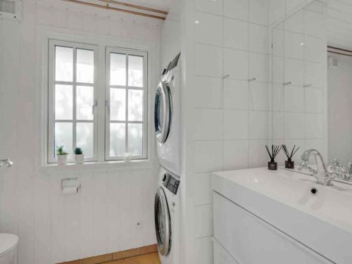 a white bathroom with a washing machine and a sink at 5 star holiday home in Hillerød in Nejede