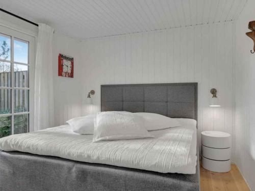 a white bedroom with a large bed and a window at 5 star holiday home in Hillerød in Nejede