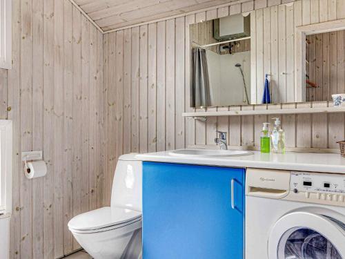 a bathroom with a washing machine and a sink at 5 star holiday home in Store Fuglede in Ornum