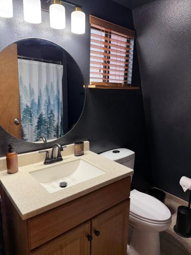 a bathroom with a sink and a toilet and a mirror at Covered Hot Tub Getaway Sleeps 9 in Duck Creek Village