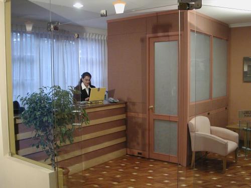 a woman sitting at a desk in an office with a laptop at Hotel Cima Argentum in Potosí