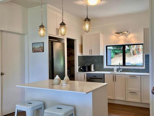 a kitchen with a large island in the middle at Beachside Bach in Russell