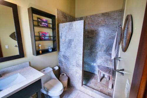 a bathroom with a shower with a toilet and a sink at La Colina - 2 People in Cohoon Ridge