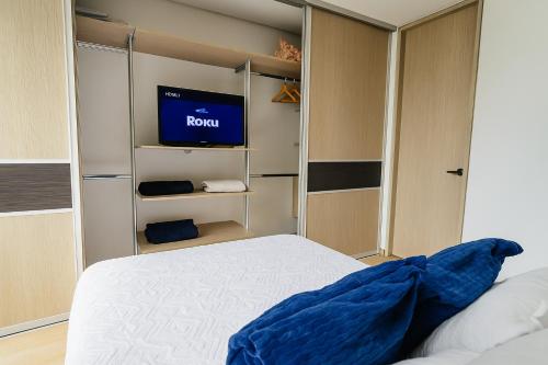 a room with a bed and a tv in it at Apartaestudio cerca centros comerciales -Refugio romantico in Ibagué
