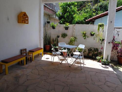 a patio with chairs and a table and a bench at Recanto da Estação in São Lourenço
