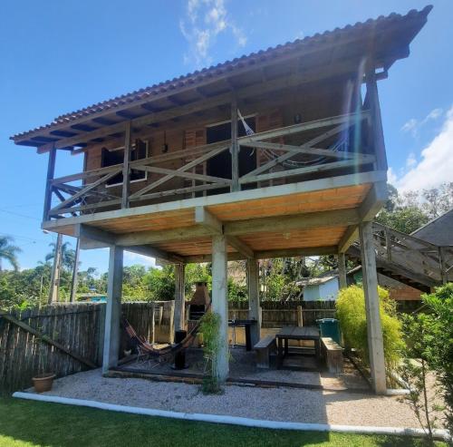 a large wooden building with a picnic table in a yard at Canto da Aracuã in Praia do Rosa