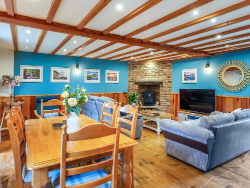 a living room with blue walls and a table and a couch at Seaton Cottage - Uk31990 in Staithes