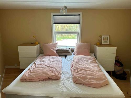 a bedroom with a bed with pink sheets and a window at 5 star holiday home in Rørvig in Rørvig