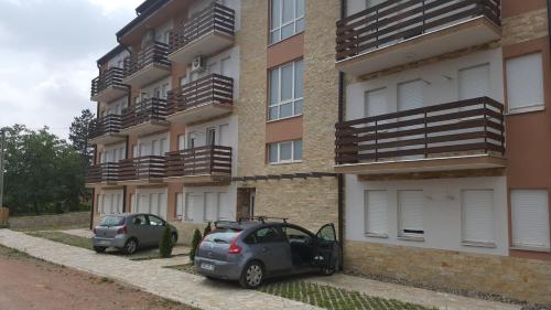 two cars parked in front of a building at Apartment Krstin Banja Vrujci in Gornja Toplica