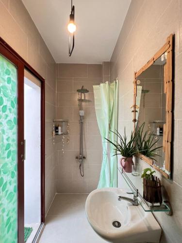 a bathroom with a sink and a shower at Terralia Villa in Lagi