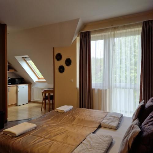 a large bed in a room with a large window at Fiore Wellness Apartman in Zalakaros
