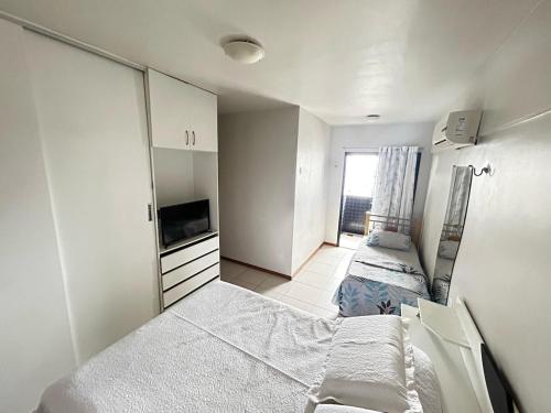 a small bedroom with two beds and a tv at Apartment 3 suites cop30 in Belém