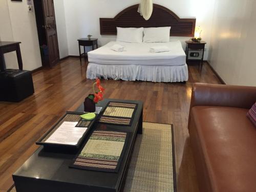 a hotel room with a bed and a couch at Nawaporn Place in Phuket Town