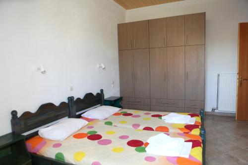 a bedroom with a bed with a colorful comforter at Splantza Apartments in Ammoudia