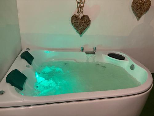 a bath tub filled with blue water in a bathroom at Private Suite with Terrace & Jacuzzi in Mérida