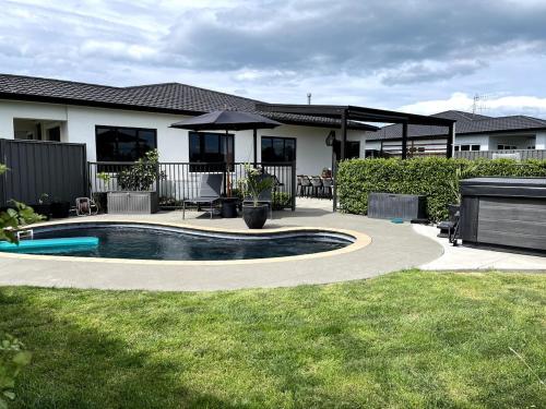 a house with a swimming pool in the yard at Pool, Spa pool, Private, Modern, Clive! in Clive