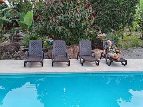 una mujer sentada en una silla junto a una piscina en Banana Lodge, en Puerto Misahuallí