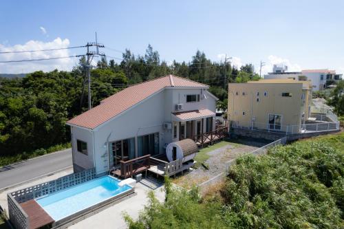 an aerial view of a house with a swimming pool at Hanare AOZORA in Onna