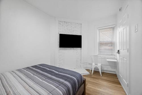 ピッツバーグにあるPittsburgh Shadyside 3B Modern and Cozy Private Bedroom with Shared Bathroomのベッドと机のある白い寝室