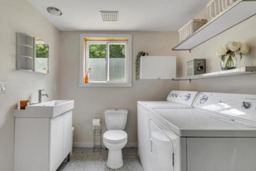 a white bathroom with a toilet and a sink at Le Nørda sur la rivière Vallée Bras du Nord in Saint-Raymond