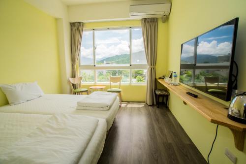 a hotel room with two beds and a window at Siang Jhan B&B in Taitung City